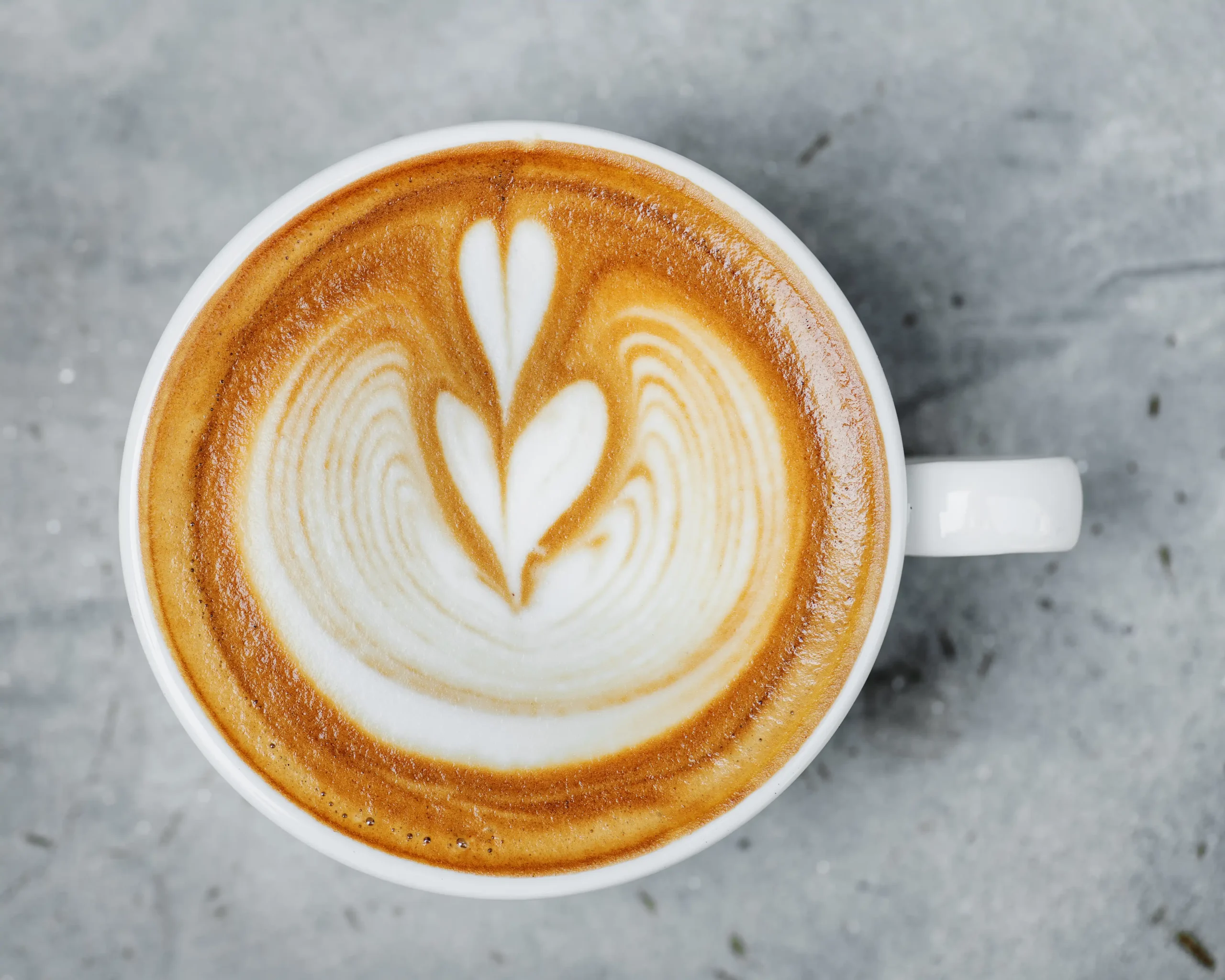 Ly cappuccino với lớp microfoam mịn dày khoảng 1cm, bề mặt latte art cân đối, thể hiện kết cấu sữa và espresso hài hòa